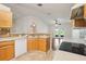 Functional kitchen with light wood cabinets, tiled countertops, and open view to the living area at 3038 Elbib, St Cloud, FL 34769