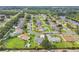 Aerial view showing a residential neighborhood with lush landscaping, various home styles, and a nearby lake at 3261 Sawgrass Creek Cir, St Cloud, FL 34772