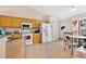 Well-lit kitchen features white appliances, wooden cabinets and access to the dining area, making it great for cooking at 3261 Sawgrass Creek Cir, St Cloud, FL 34772