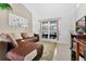 Comfortable living room featuring a plush sofa, neutral-toned walls, tile floor and natural light from the slider at 3261 Sawgrass Creek Cir, St Cloud, FL 34772