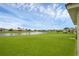 Expansive backyard with lush green grass, a serene lake and neighborhood views at 3617 Northwoods Dr, Kissimmee, FL 34746