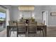 A cozy dining room featuring a modern chandelier, a wooden dining table, and natural lighting at 3617 Northwoods Dr, Kissimmee, FL 34746
