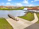 Scenic lake view featuring a boat ramp, dock, and covered pier with surrounding homes and lush landscaping at 3617 Northwoods Dr, Kissimmee, FL 34746