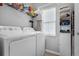Bright laundry room with modern appliances, shelves, and a window for natural light at 3617 Northwoods Dr, Kissimmee, FL 34746
