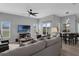 Open-concept living room with ceiling fan, neutral furniture, and large windows overlooking the backyard at 3617 Northwoods Dr, Kissimmee, FL 34746