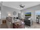 Bright living room with gray walls, neutral furniture, ceiling fan and views of the outdoors at 3617 Northwoods Dr, Kissimmee, FL 34746