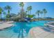 Community pool with a water slide, palm trees, and comfortable lounge seating for residents to enjoy at 3617 Northwoods Dr, Kissimmee, FL 34746