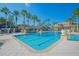 Beautiful community pool surrounded by palm trees and outdoor seating for relaxation at 3617 Northwoods Dr, Kissimmee, FL 34746
