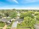 Aerial view of a single-story home with mature trees, a well-kept lawn, and a paved driveway at 3804 Anthony Ln, Orlando, FL 32822