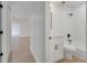 Hallway leading to an updated bathroom with new fixtures, vanity with quartz countertop, and tiled shower over tub at 3804 Anthony Ln, Orlando, FL 32822
