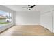 Bright bedroom featuring wood-look floors, a ceiling fan, and a large window that provides natural light at 3804 Anthony Ln, Orlando, FL 32822