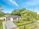 Landscaped single-story home with a manicured lawn, mature trees, and a newly paved driveway at 3804 Anthony Ln, Orlando, FL 32822