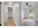 Hallway leading to a bedroom with a ceiling fan and natural light from the window at 3804 Anthony Ln, Orlando, FL 32822
