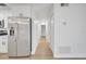 Long hallway with stainless steel refrigerator and views down the hall to the bedrooms at 3804 Anthony Ln, Orlando, FL 32822