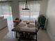 Sunlit dining area with view of the pool, features modern light fixture and seating for six at 416 Sea Willow Dr, Kissimmee, FL 34743