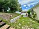 A backyard featuring a retaining wall, privacy fence, mature trees, and a gazebo with a brick-paved sitting area at 453 Alston Dr, Orlando, FL 32835