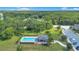 Aerial shot featuring a community pool surrounded by trees, manicured lawns, lounge chairs, and a clubhouse at 5103 Jones Rd, St Cloud, FL 34771