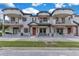 Inviting townhome featuring dual balconies, stone accents and an orange front door with a wreath at 5103 Jones Rd, St Cloud, FL 34771