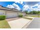 A low angle view of a modern two-car garage with manicured landscaping at 5103 Jones Rd, St Cloud, FL 34771