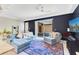 Bright living room features a comfortable blue sofa, plush rug, and sliding glass doors to the outside at 5103 Jones Rd, St Cloud, FL 34771