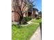 Charming exterior view of townhomes with brick and wood, mature landscaping, and manicured lawn on a sunny day at 5144 Picadilly Circus Ct # 2, Orlando, FL 32839