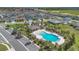 Aerial view of a sparkling community pool and clubhouse with lush landscaping and ample seating at 5225 Tuscany Ln, Davenport, FL 33897