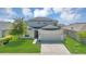 Charming two-story home featuring a well-manicured lawn, mature trees, and a two-car garage at 5225 Tuscany Ln, Davenport, FL 33897