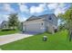 Two-story home with well-maintained lawn, paved driveway, and attached two car garage at 5225 Tuscany Ln, Davenport, FL 33897