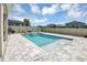 Relaxing pool with a tanning ledge and fountain feature surrounded by gray pavers in the backyard at 5225 Tuscany Ln, Davenport, FL 33897