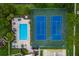 Overhead view of the community pool and tennis courts and lush green landscaping with beautiful blue skies at 5251 Brook Ct # 242, Orlando, FL 32811