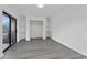 Bright bedroom featuring wood floors, a closet, and a sliding glass door leading to the balcony at 5251 Brook Ct # 242, Orlando, FL 32811