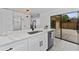 Newly renovated kitchen with stainless steel sink, white cabinets, quartz countertops, and patio access at 5251 Brook Ct # 242, Orlando, FL 32811