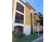 Three-story condo building showcasing screened lanais, tan and white exterior, and well-maintained landscaping at 6169 Metrowest Blvd # 208, Orlando, FL 32835