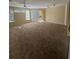 Spacious living room featuring carpet floors, natural lighting, and sliding glass door to balcony at 6169 Metrowest Blvd # 208, Orlando, FL 32835