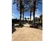 Stunning entrance to the community pool area lined with lush palm trees and manicured landscaping at 6169 Metrowest Blvd # 208, Orlando, FL 32835