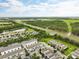 Community aerial view with pond, green spaces, highway, and well-manicured lawns at 6834 Habitat Dr, Harmony, FL 34773