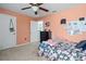 Cozy bedroom with carpet flooring, ceiling fan, and doorway to the next room at 6834 Habitat Dr, Harmony, FL 34773