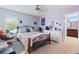 Bedroom with carpet flooring, a ceiling fan, and a doorway to the bathroom at 6834 Habitat Dr, Harmony, FL 34773
