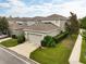 Beautiful two-story home featuring a two-car garage, manicured lawn, and mature landscaping at 6834 Habitat Dr, Harmony, FL 34773
