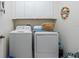 This laundry room is equipped with a washer and dryer, and upper cabinets for storage at 6834 Habitat Dr, Harmony, FL 34773