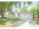 Single-story home with a large front lawn, two-car garage, and traditional architectural details at 7410 Orange Crest Cir, Lakeland, FL 33810