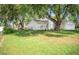 Home with a well-maintained lawn and mature trees, adjacent to a detached two-car garage at 7410 Orange Crest Cir, Lakeland, FL 33810