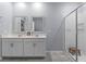 Modern bathroom with double vanity, framed mirrors, and glass-enclosed shower with built-in bench at 757 Citrus Reserve Blvd, Davenport, FL 33837
