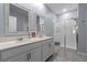 Bathroom features dual sinks with framed mirrors and glass enclosed shower with bench at 757 Citrus Reserve Blvd, Davenport, FL 33837