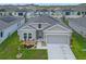 Inviting single-Gathering home featuring a well-maintained lawn, attached two-car garage, and covered entryway at 757 Citrus Reserve Blvd, Davenport, FL 33837