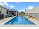 Backyard showcases an in-ground pool with a waterfall feature, surrounded by a paved patio and privacy fence at 757 Citrus Reserve Blvd, Davenport, FL 33837