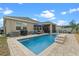 Backyard features a stunning in-ground pool with a seating area, complemented by comfortable lounge chairs and an umbrella at 757 Citrus Reserve Blvd, Davenport, FL 33837