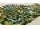 Aerial view of the community pool, lazy river, tennis courts, and parking lot at 7622 Oakmoss Loop, Davenport, FL 33837