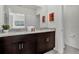 Bathroom features a dual sink vanity with granite countertop, framed mirror, and modern fixtures at 7622 Oakmoss Loop, Davenport, FL 33837