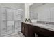 Bathroom featuring a glass enclosed shower and granite countertop vanity with double sinks at 7622 Oakmoss Loop, Davenport, FL 33837